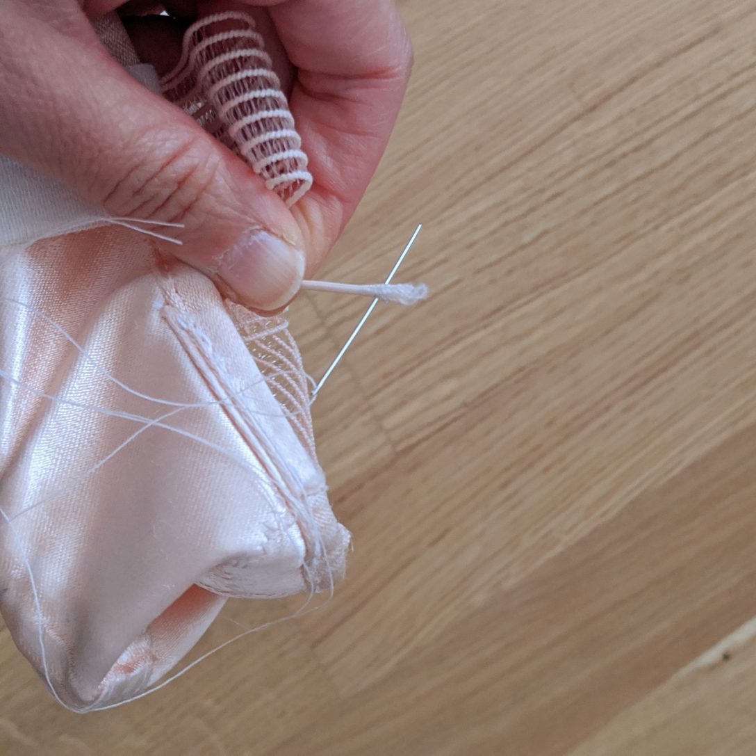 Sewing through a free end of the elastic.